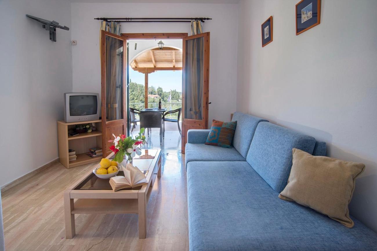 Living room with blue sofa and open doors to a balcony with countryside view