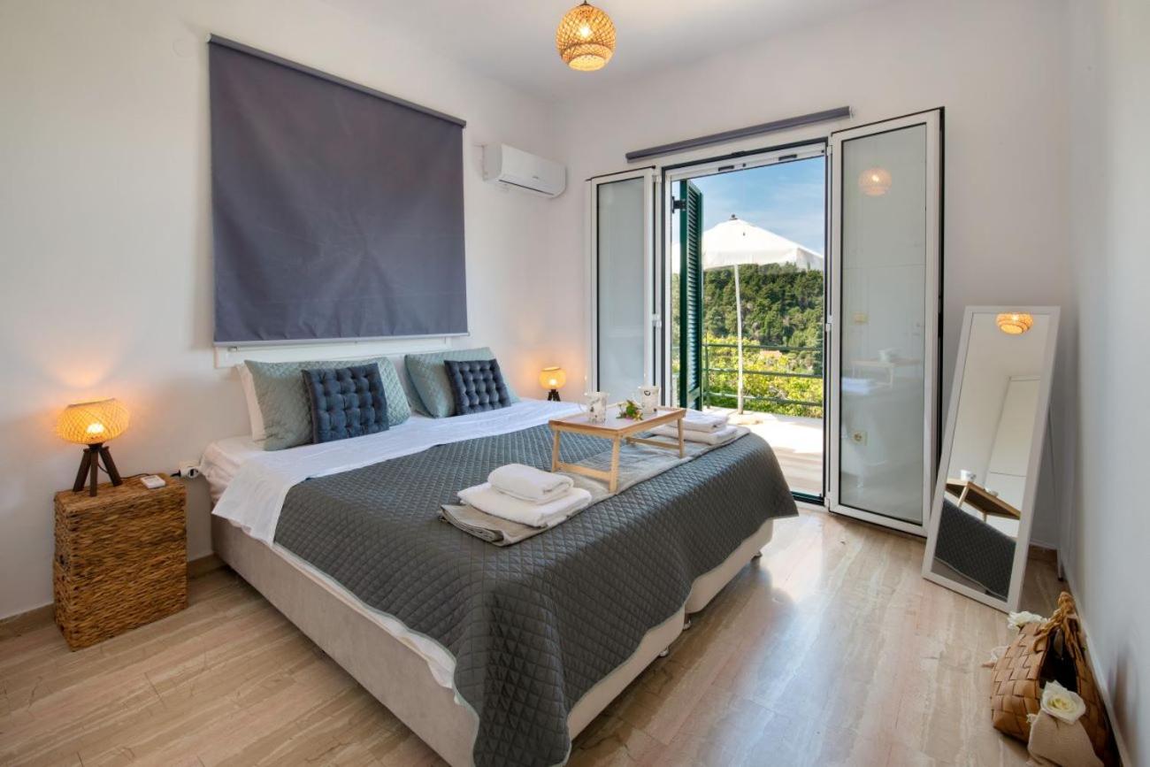 Bright bedroom with double bed and sliding glass door to a balcony with garden view